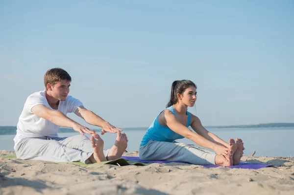 Ungt par, der praktiserer yoga - Stock-foto