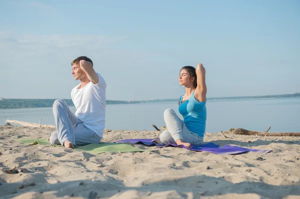 Jeune couple pratiquant le yoga — Photo