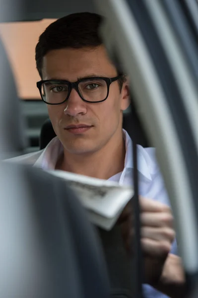 Empresário no carro lendo jornal — Fotografia de Stock