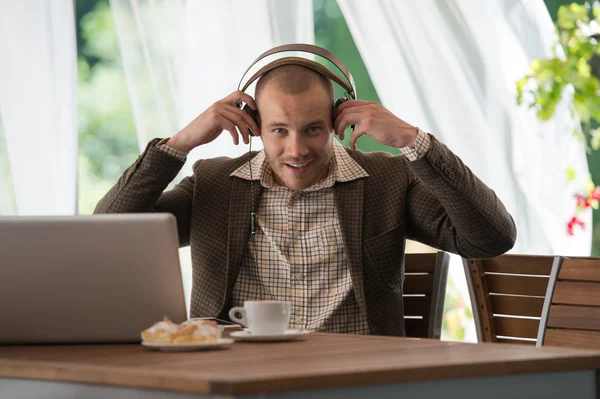 Businessman resting at cafe and listening music — Stock Photo, Image