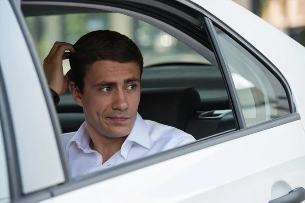 Obchodní muž na zadním sedadle automobilu — Stock fotografie