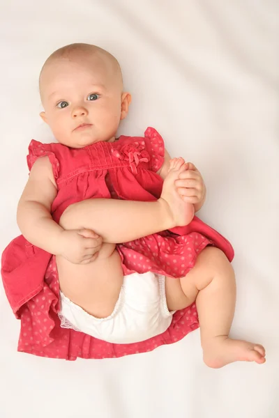 Baby girl in red dress (6 month) Stock Photo