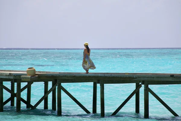 Dívka chodí dřevěné molo podél oceánu — Stock fotografie
