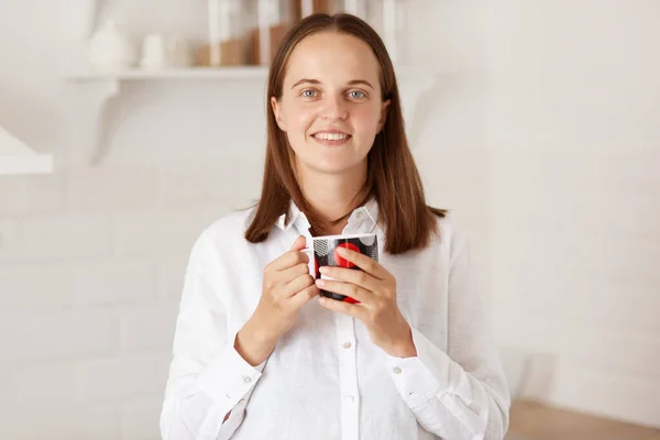 Крытый Снимок Улыбающейся Красивой Женщины Пьющей Чашку Кофе Кухне Стоящей — стоковое фото