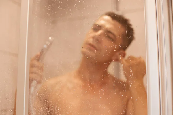 Portret Młodego Ciemnowłosego Mężczyzny Myjącego Ucho Pod Prysznicem Stojącego Pod — Zdjęcie stockowe
