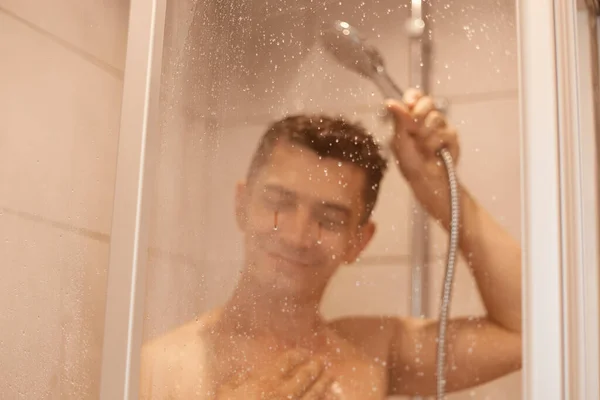 Szczęśliwy Uśmiechnięty Zadowolony Mężczyzna Pozujący Nago Pod Prysznicem Szybą Kroplami — Zdjęcie stockowe