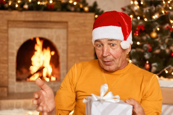 Överraskad Man Bär Casual Kläder Och Santa Claus Hatt Hålla — Stockfoto