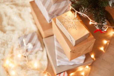 En üstteki hediye kutuları yığını Xmas ağacının altında beyaz yumuşak halı süslenmiş, mutlu Noeller ve mutlu yıllar..