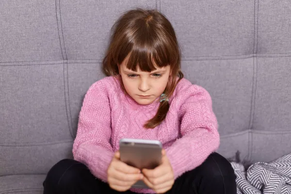 Little Girl Wearing Warm Pink Sweater Using Smartphone Sitting Couch — Stock Photo, Image