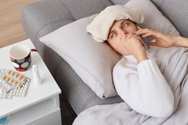 Young Adult Ill Woman Wet Towel Her Head Lying Sofa — Stock Photo, Image