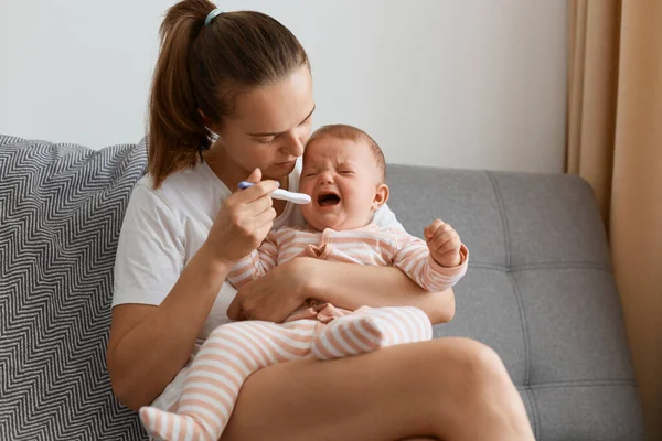 Indoor Shot Mother Measuring Temperature Her Sick Crying Baby Sitting — Stock Photo, Image