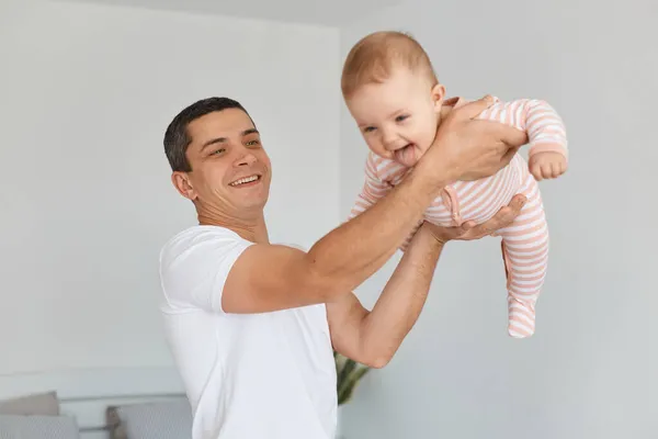 Positive Brunette Man Wearing White Casual Shirt Holding His Infant — Stock Photo, Image