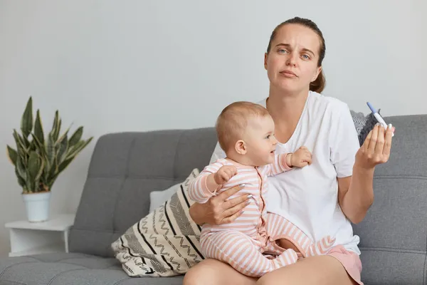 Verwirrte Frau Weißem Lässigem Shirt Posiert Mit Ihrer Kleinen Tochter — Stockfoto