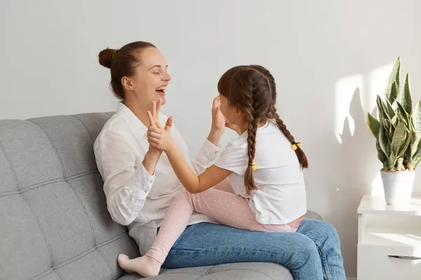 Extremely Happy Young Adult Mother Playing Her Charming Daughter Pigtails — Stock Photo, Image