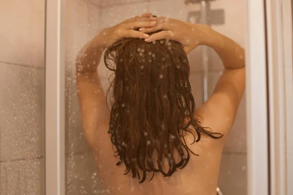 Tylne Zdjęcie Ciemnowłosej Kobiety Nagim Ciałem Bierze Prysznic Szklanymi Drzwiami — Zdjęcie stockowe