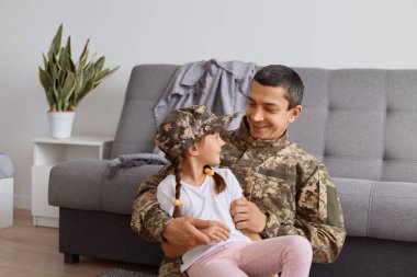 Kamuflaj üniforması giyen Kafkasyalı bir askerin ordudan eve dönüşünü, küçük kızıyla vakit geçirmesini kanepenin yanında oturup birbirine bakmasını ve çok şey kaçırmasını hayal etmek..