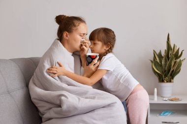 Hasta, sağlıksız, burnu akan, ateşi yüksek, sıcak çay içen, annesine sarılan küçük, sevimli bir kızın portresi, daha iyi hissetmesini istiyor..
