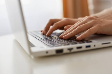 Kimliği belirsiz bir kadının bilgisayarında, klavyesinde yazı yazarken, programlarken, portatif not defteri üzerinde çevrimiçi çalışmasını yaparken çekilmiş kapalı çekimler..