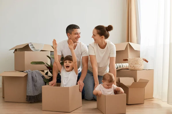 Young Couple Relocating New Flat Riding Children Cardboard Boxes Having — Stock Photo, Image
