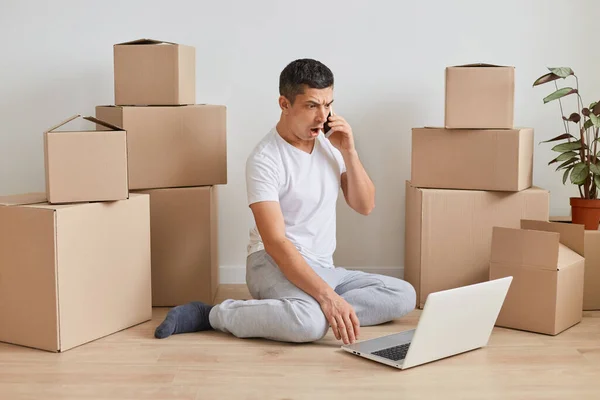 Disparo Horizontal Sorprendido Hombre Vestido Con Camiseta Blanca Sentado Suelo — Foto de Stock