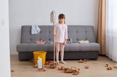 Odanın zeminini yıkayan, elinde paspas tutan, üzgün bir şekilde kameraya bakan, üzüntüsünü dile getiren bir kızın portresi dağınıklığı temizlemek istemiyor..