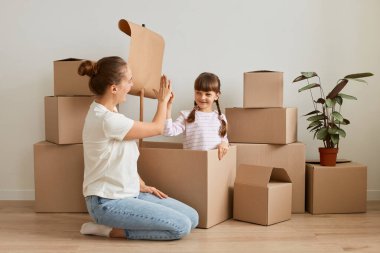 Çekici bir kadının kızıyla oynadığı, taşınma sırasında bayrakla gemi yaptığı, denizcilik oynadığı, paketleri açarken dinlendiği, beşer beşer beşer verdiği kapalı çekimler..