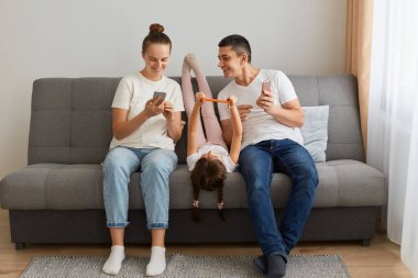 Evin içinde, farklı elektronik aletler kullanarak, komik videolar izleyerek, olumlu duygular ifade ederek, günlük giysiler giyerek,.