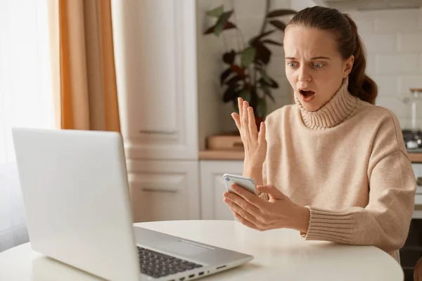 Portrait Shocked Woman Wearing Beige Sweater Sitting Kitchen Working Online — Stock Photo, Image