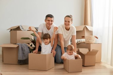 Yeni bir daireye taşınırken, karton kutularla çevrili, beyaz t-shirtler giymiş, çocuklar karton kutularda oturuyor ve oyun oynuyorlardı..