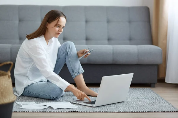 Horizontal Shot Concentrated Woman Wearing White Shirt Jeans Sitting Floor — Stock Photo, Image