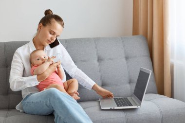 Beyaz gömlek ve kot pantolon giyen meşgul bir beyaz kadın küçük kızıyla öksürük içinde oturuyor, annesi kimlik için su veriyor ve cep telefonuyla konuşuyor, sakin bir ifadeyle, kızına bakıyor..