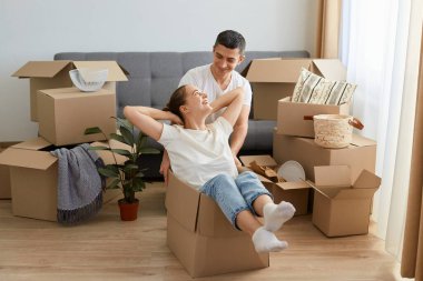 İyimser bir çiftin taşınma gününde yeni bir dairede karton kutularla eğlenmesinin portresi, yeni bir daireye taşınmaktan mutlu olan karı koca, sevgi ve kibarlığı ifade ediyor..