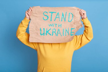 Savaşa karşı barışçıl bir gösteri sırasında sarı kapüşonlu kadın portresi, Ukrayna 'nın desteği, üzerinde 