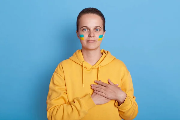 Νεαρή Ενήλικη Γυναίκα Κίτρινη Κουκούλα Και Σημαία Ουκρανίας Στο Μάγουλό — Φωτογραφία Αρχείου