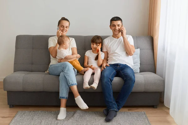 Horizontal Shot Busy Family Sitting Sofa Having Conversation Smart Phone — Stock Photo, Image