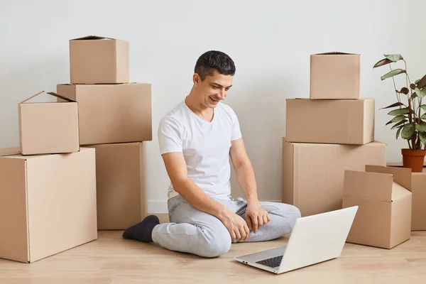 Indoor Shot Brunette Man Sitting Floor Laptop Leave Apartment Happy — Fotografia de Stock