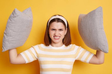 Kapalı alanda genç bir kadının kollarını kaldırıp yastığını tutarken, dişlerini sıkarken, sinirli bir ifadeyle çığlık atarken, sabahın erken saatlerinde uyanmak istemezken..