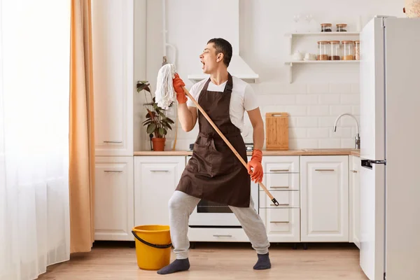 Full Length Photo Young Guy Cleaning Kitchen Having Fun Listening — Fotografia de Stock