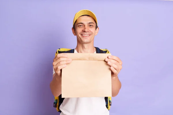 Satisfied Delivery Man White Shirt Cap Holding Paper Packet Food — Stock fotografie