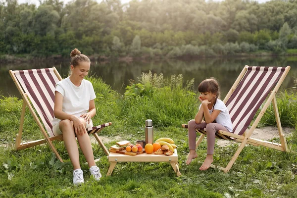 Portrait Happy Mother Her Daughter Sitting Folding Picnic Chairs Eating — Fotografia de Stock