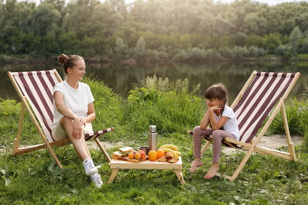 Ulkona Laukaus Naisen Kanssa Pieni Tyttö Istuu Taittuva Piknik Tuolit — kuvapankkivalokuva