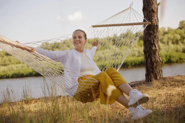 Outdoor Shot Smiling Delighted Caucasian Woman Sitting Hammock Water Looking — Stockfoto