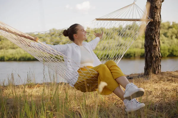 Outdoor Shot Relaxed Satisfied Delighted Woman Sitting Hammock Water Looking — Photo