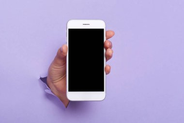 Photo of human's hand showing mobile phone with black empty display, mockup for promotion, advertisement area, cell phone with blank screen.