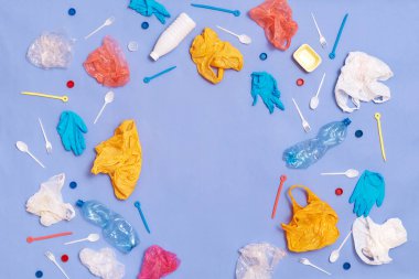 Plastic pollution. Environmental and ecology problems, air pollution. Blue wall and much plastic garbage around.