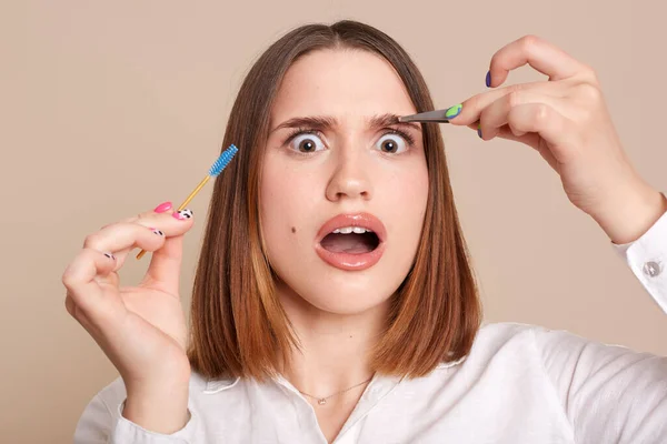 Portrait Shocked Scared Female Beauty Salon Holding Eyebrow Brush Tweezers — Stok fotoğraf