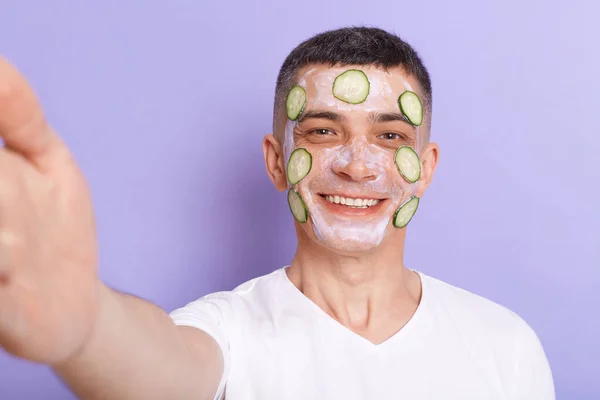 Portrait Smiling Man Wearing White Shirt Applying Mask Cucumber Slices — Zdjęcie stockowe