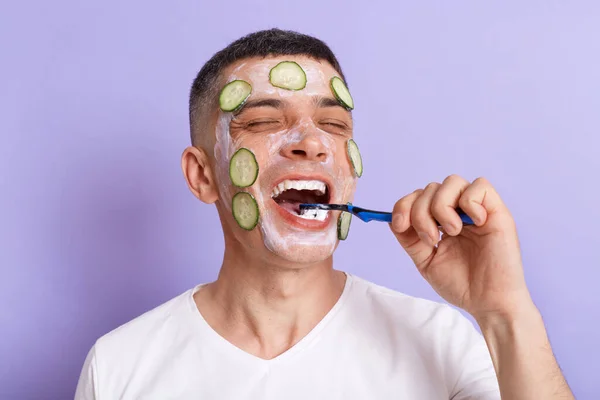 Positive Happy Man Wearing White Shirt Applying Mask Cucumber Slices — 图库照片