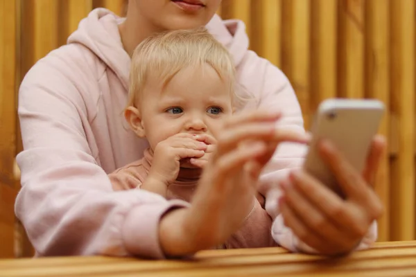 Portrait Fasceless Woman Sitting Using Cell Phone Holding Baby Daughter — Stock Photo, Image