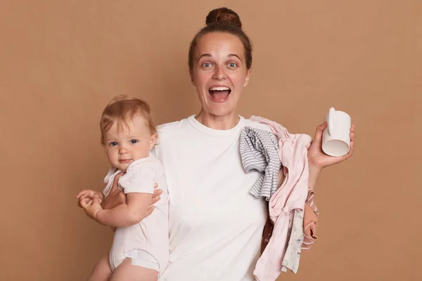 Madre Joven Extremadamente Feliz Con Peinado Moño Sosteniendo Hija Pequeña —  Fotos de Stock